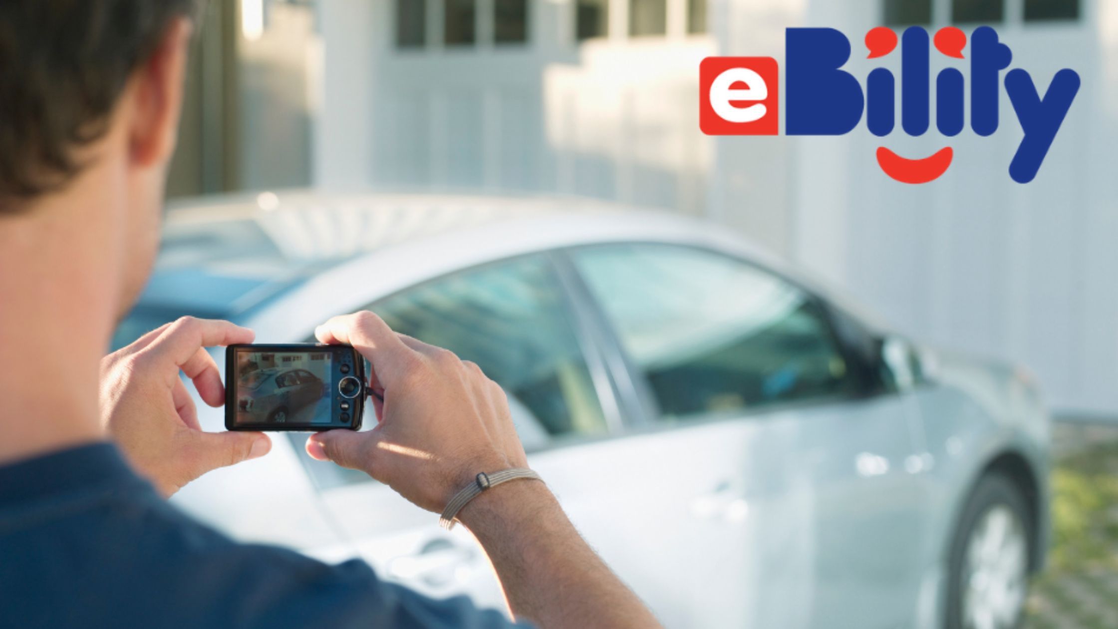 A man takes a photo of a car with his phone.